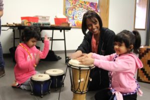 volunteer and campers playing with hand drums