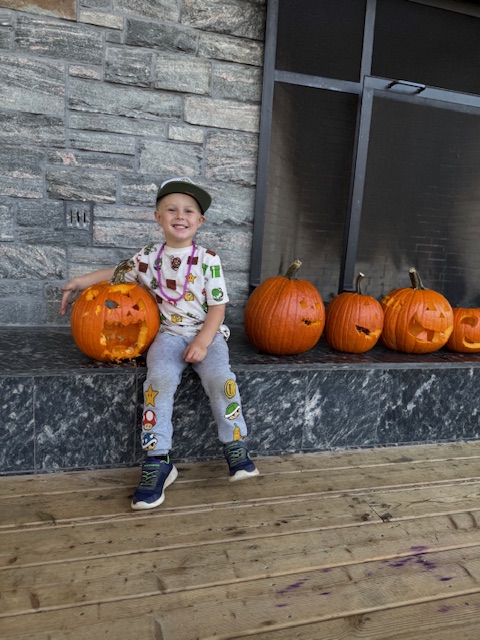 camper with line of pumpkins at camp