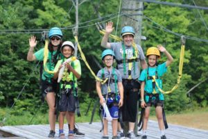 volunteers and campers on high ropes course at ooch muskoka