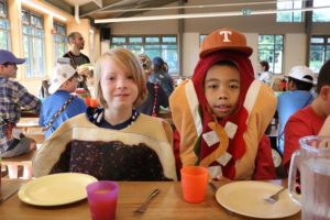 two campers dressed up in costume in the dining hall at camp