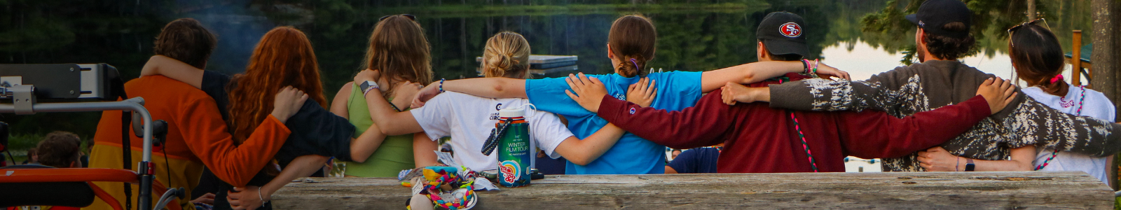 campers with arms around each other at campfire
