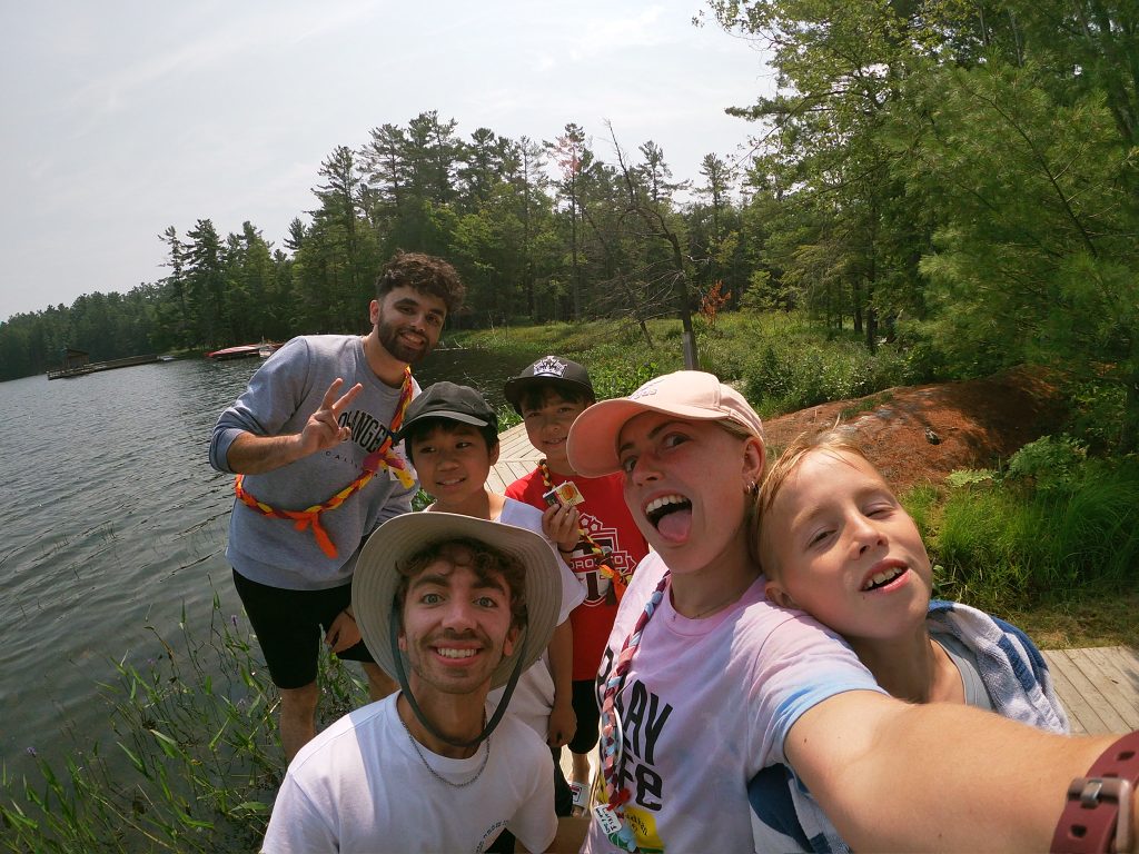 counsellors and campers on the shores of the lake at camp