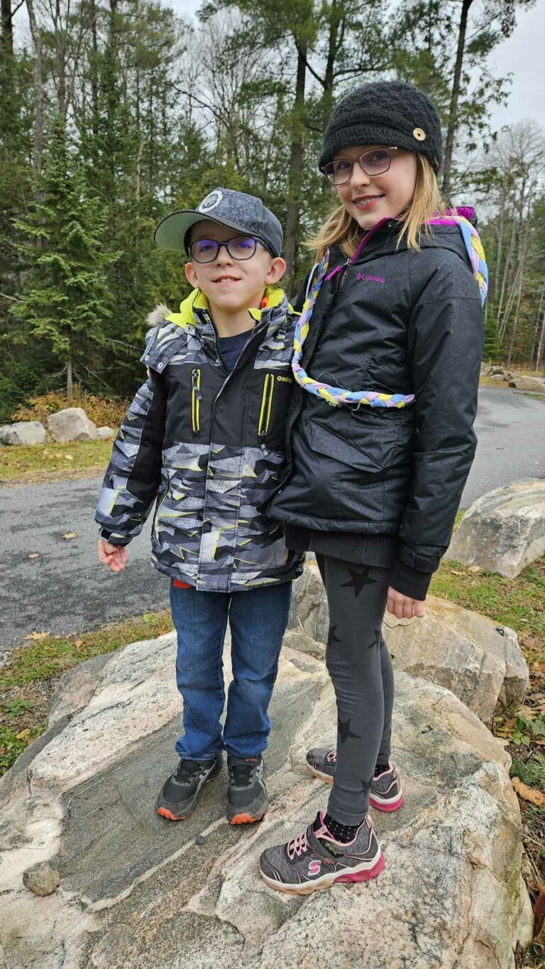 brock and faye standing on a big rock at camp