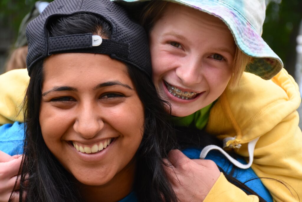 kiran and camper smiling wearing hats