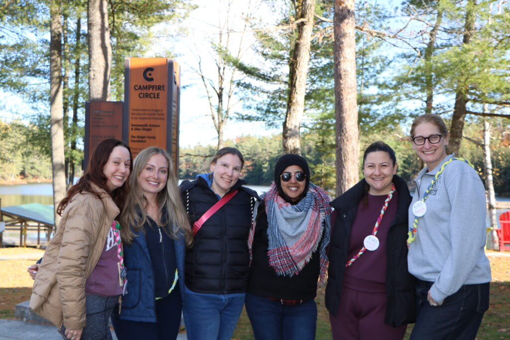 shaindy with volunteers outside at camp on a fall day