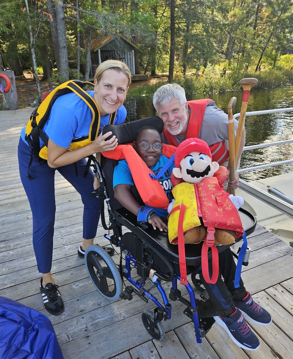 ethan with volunteers on the dock at camp
