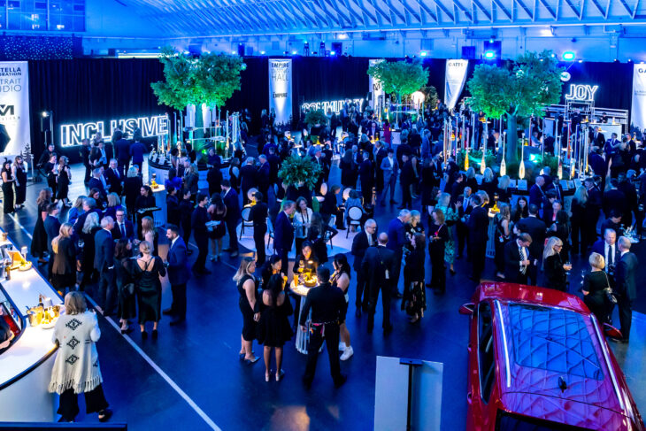 event attendees standing and socializing with other in a beautifully lit event space