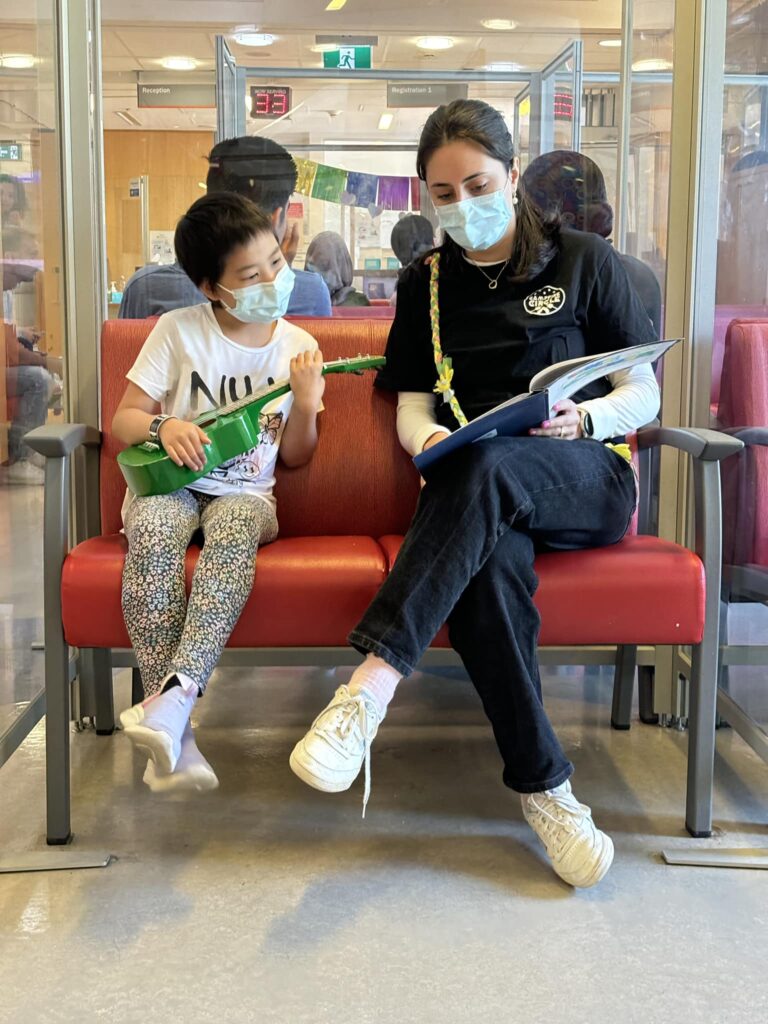 radda and campfire circle staff playing ukulele together