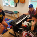 camper playing music with volunteers