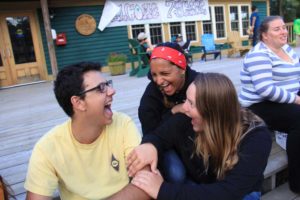 campers laughing with each other on the steps to the med shed at camp