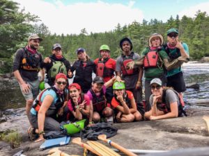 counselors and campers in life jackets on canoe trip