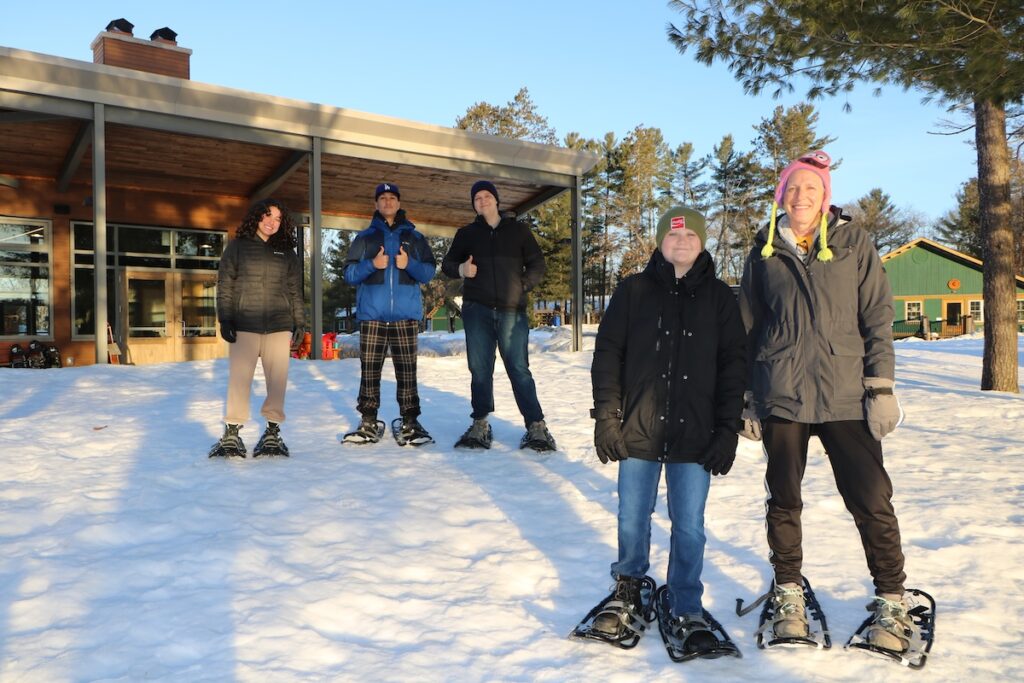 traci at camp with volunteer and campers outside in the snow