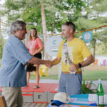 Stu Lang, philanthropist, shakes hands with Alex Robertson, CEO of Campfire Circle