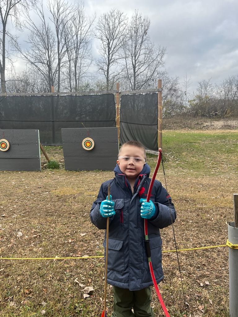 ben holding a bow and arrow at archery