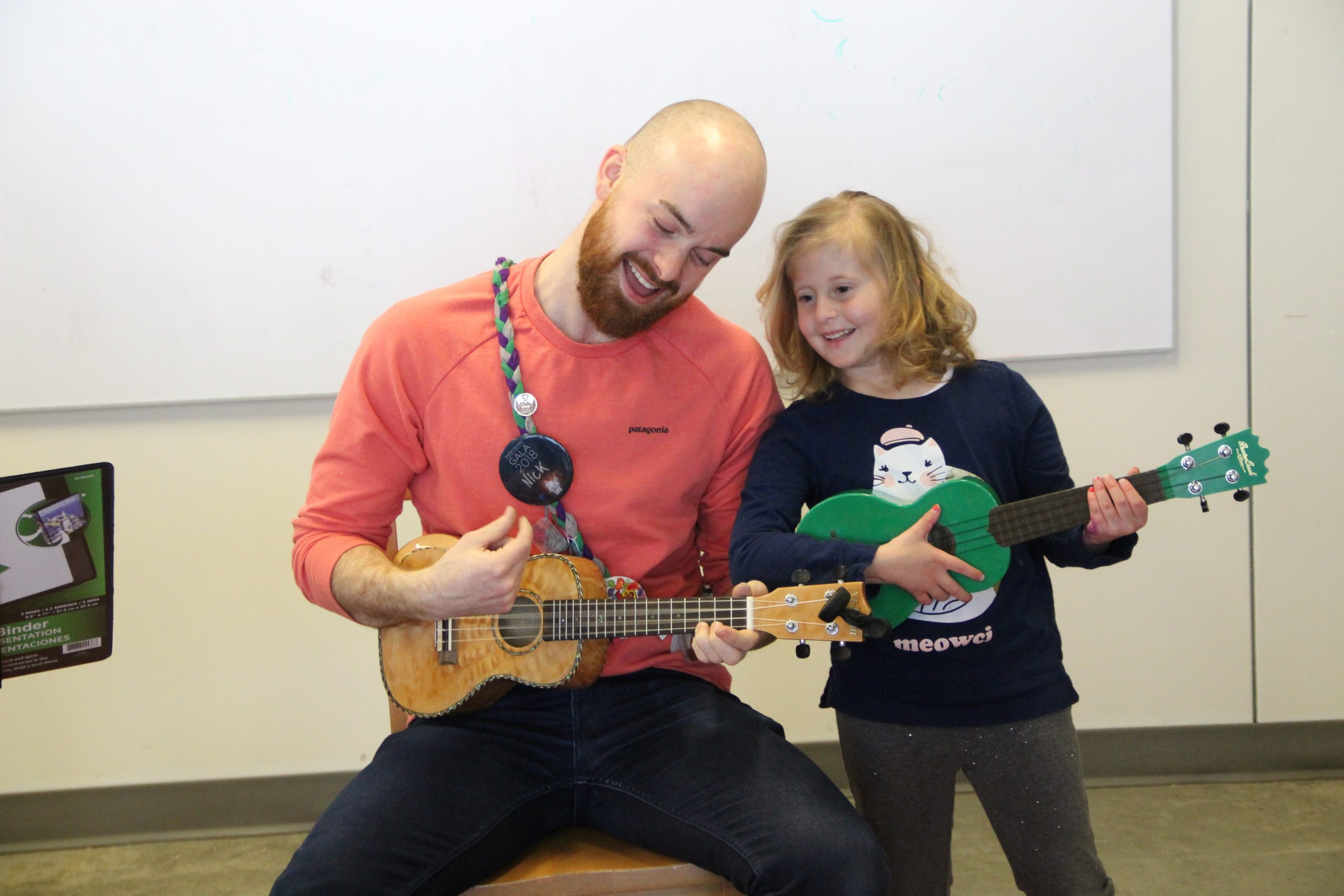 camper playing ukulele with staff member