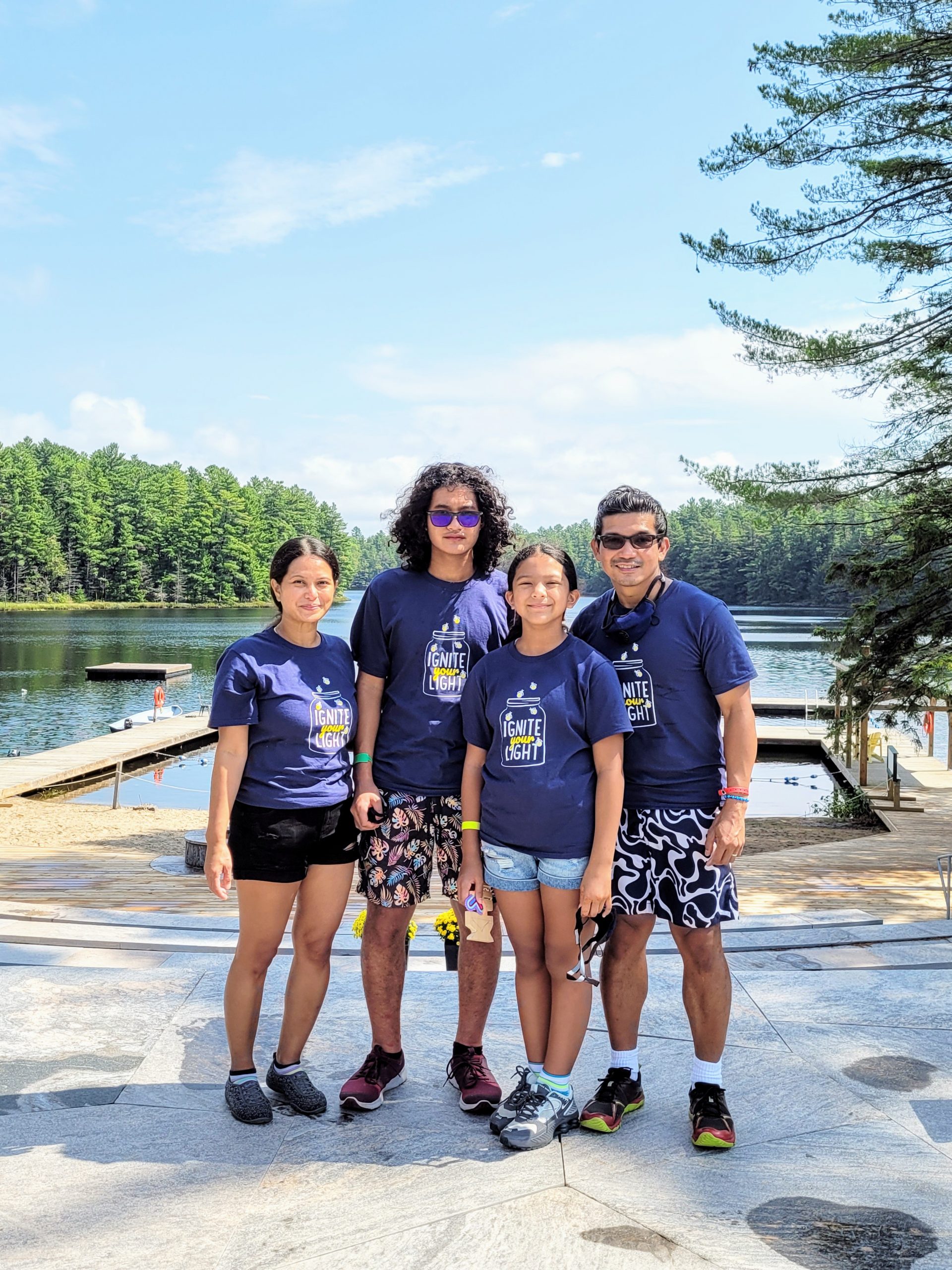 family standing on dock at camp for a picture