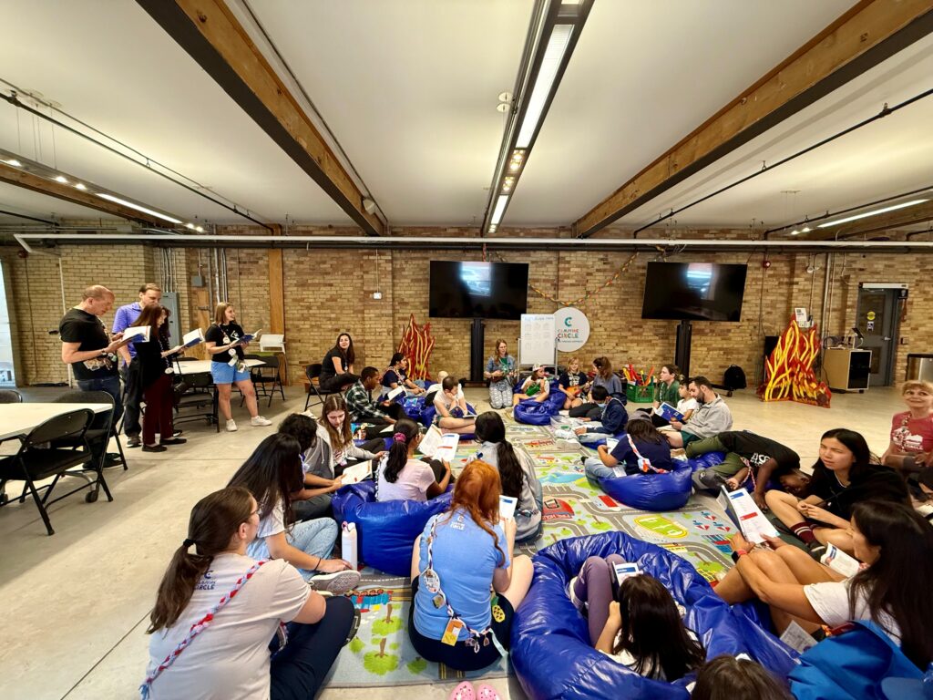 priscilla singing at camp event with campers, staff and volunteers