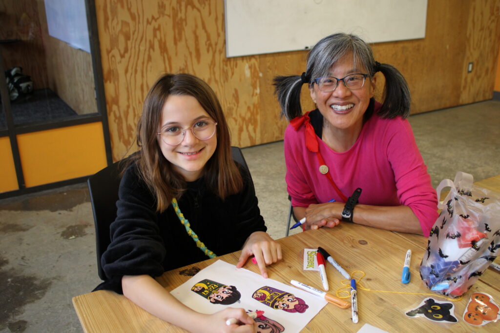 volunteer and camper doing arts and crafts
