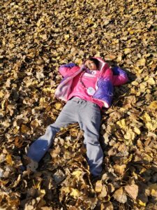 kaley lying in the leaves at camp