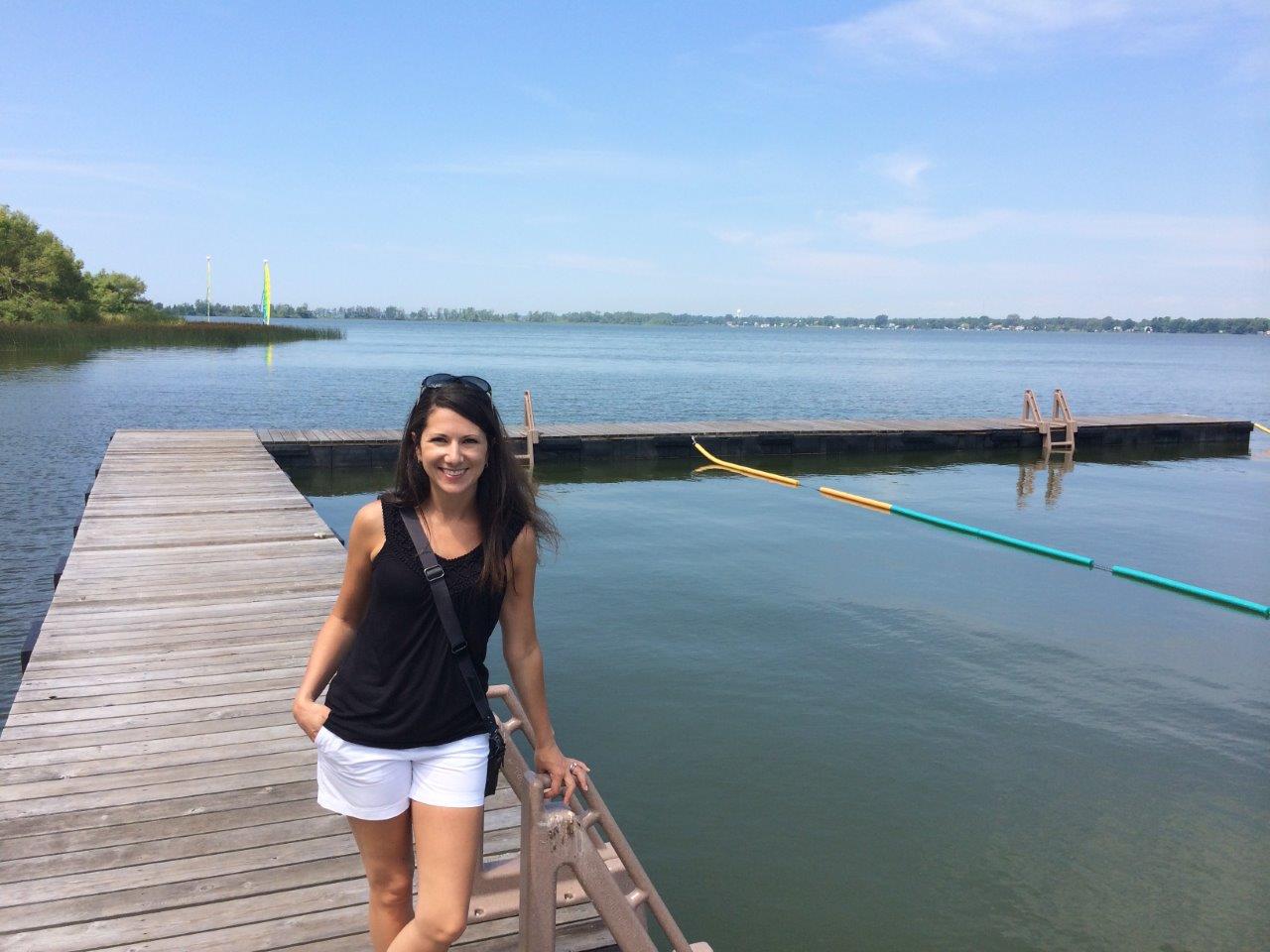 kristine standing on a dock on the water at camp