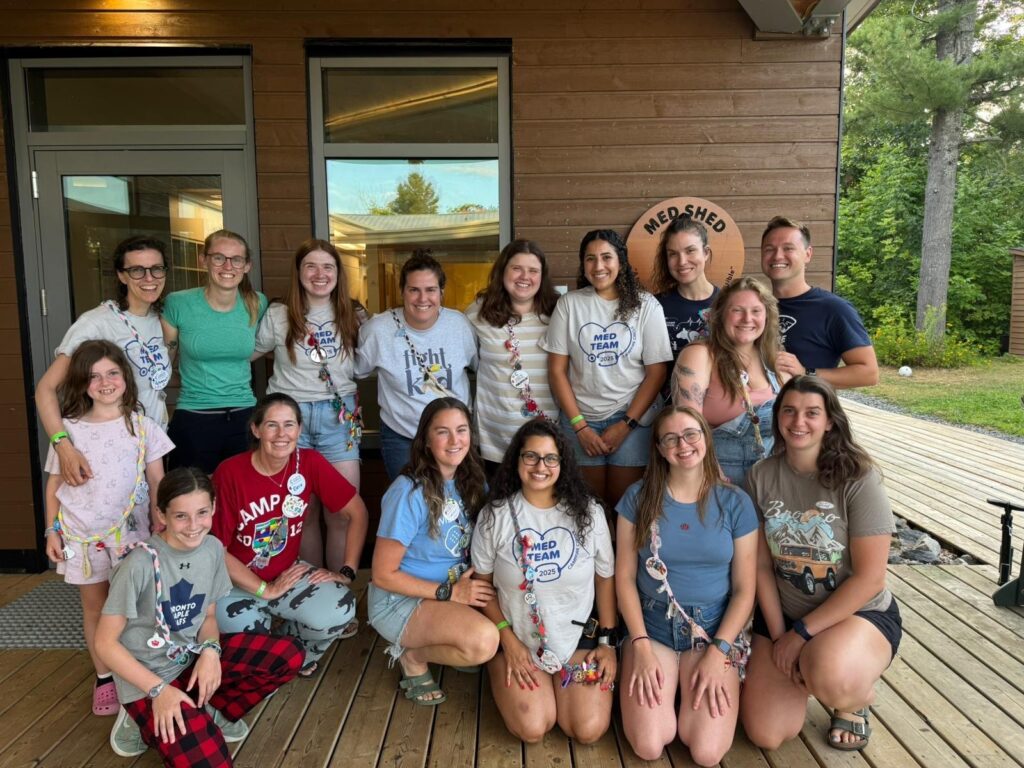 maram with volunteers and campers outside the med shed at camp